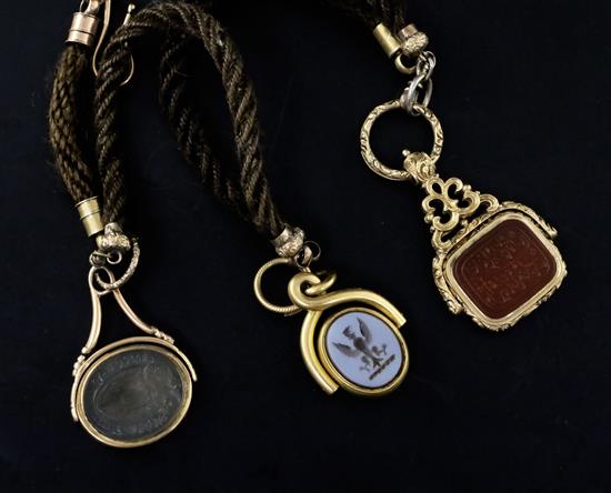 A 19th century plaited hair albert hung with three gold mounted or gold overlaid chalcedony set spinning fob seals, albert 92cm.